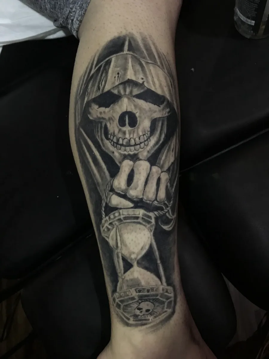 Tatuagem de ceifador com ampulheta em realismo preto e cinza