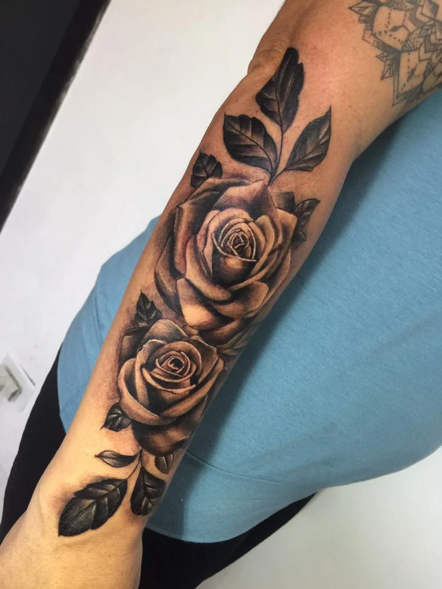 Tatuagem de rosas em realismo preto e cinza no antebraço